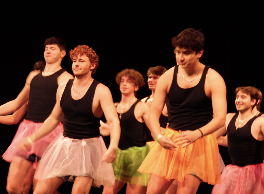 Delta Chi members perform a decades dance routine with tutus at the homecoming talent show in Young Auditorium.
