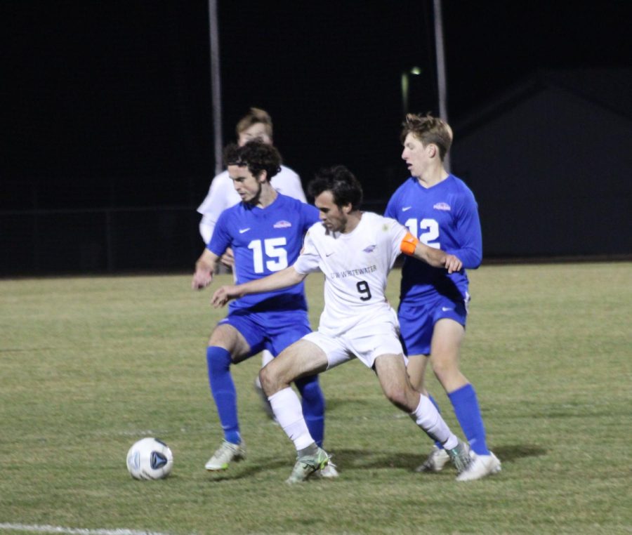 Senior Midfielder Will Hamilton attempts to maneuver the ball away from two UW-Platteville players, Oct. 28th, 2022. 
