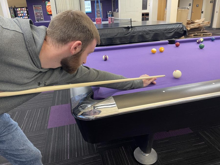 Junior Financial Planning major Kyle Helker playing pool in the University Center.