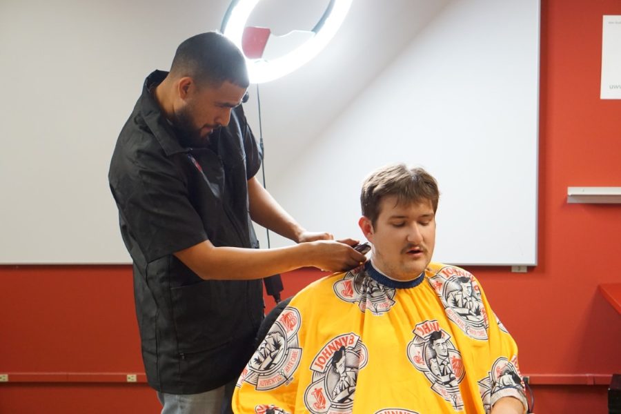 Underground Cutz owner Cesar Mendoza cuts a students hair in the Anderson Library lower level November 14, 2022.
