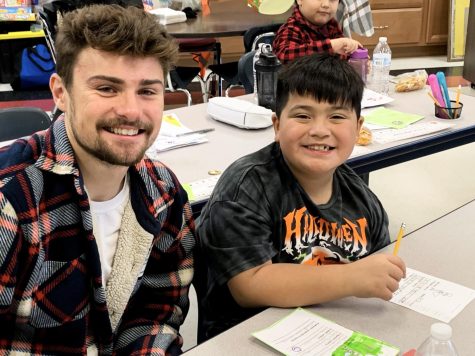 Native American Support Services Coordinator, for the Student Diversity for Education and Success programs, Michael Bose, and little scholar buddy celebrate goals that have been met with smiley faces, for the Little Scholars Program at Converse Elementary, in Beloit, Wisconsin.
