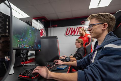 Students test out the new gaming computers in the university’s Esports arena in Chalmer Davee Library as Dylan Gentilcore, standing rear, new Esports varsity head coach, looks on.
