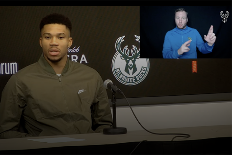 Brice Christianson interprets what Milwaukee Bucks star Giannis Antetokounmpo is saying during a news conference after a game in late November.