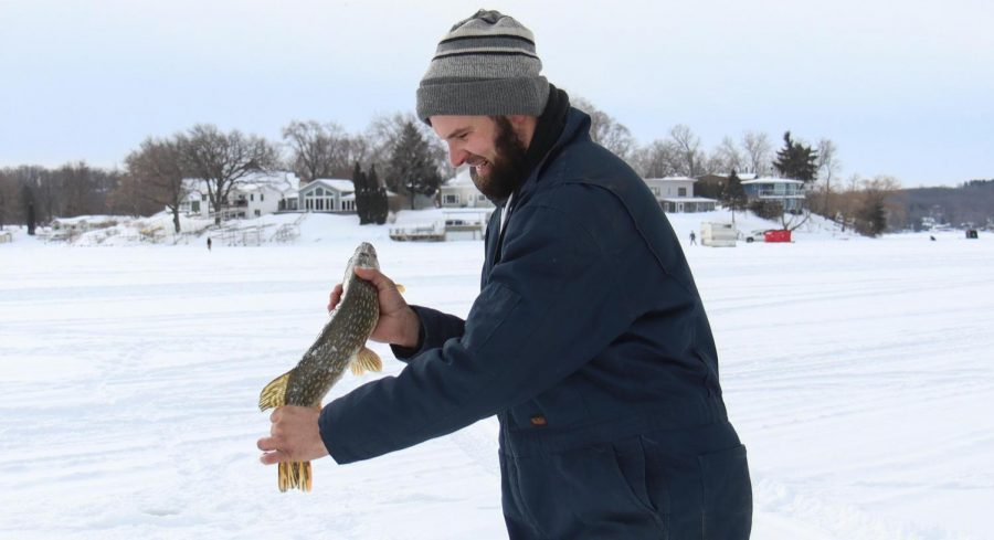Tylor Fraser carries a northern pike across Whitewater Lake, which he caught while participating in the Whitewater Lions Club 45th Annual Fish-A-Ree.
