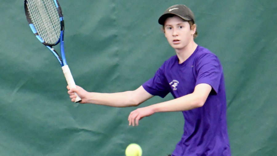 Tyler Nelson raises his racket to hit a forehand. 