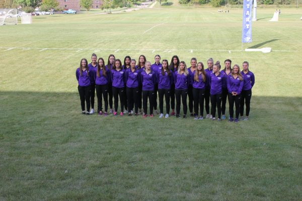 Womens Cross Country team standing together for a team photo before warming up.