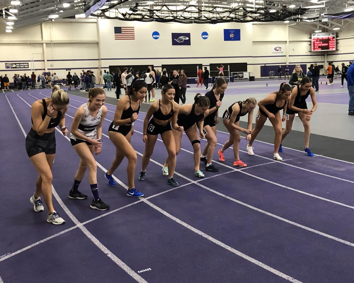 Current and former Warhawks line up in preparation for the women’s 1500 meter dash during the Alumni/Intersquad Meet at Kachel Fieldhouse in Whitewater, Wisconsin, December 9, 2023.
