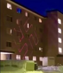 A group of neo-Nazis shine the image of a swastika onto the side of Knilans Hall the evening of Sunday, Jan. 21. 