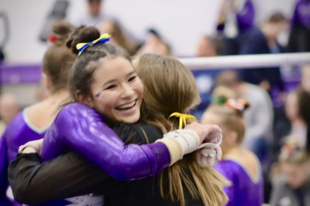 Freshman All Around Paige Magel hugs Assistant Coach Chloe Edgren as she completes the bars and lands successfully at the Tournament against UW-Stevens Point  Blue Devils Saturday Feb. 17, 2024 in the Williams Center. 