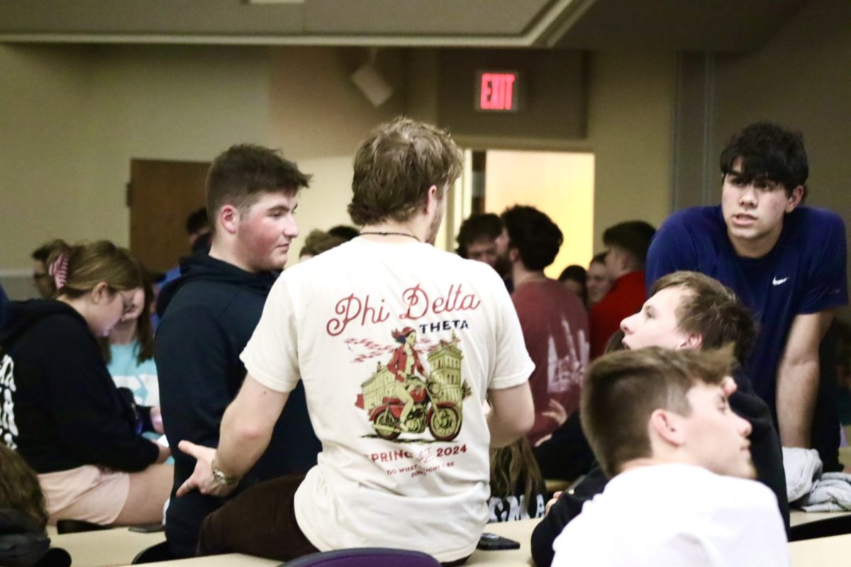(center) Senior Business Major Bobby Mann, the Phi Delta Theta Wisconsin Chair and IFC President talks amongst his fellow Greeks before Hiding in Heide Tuesday evening, March 12, 2024.