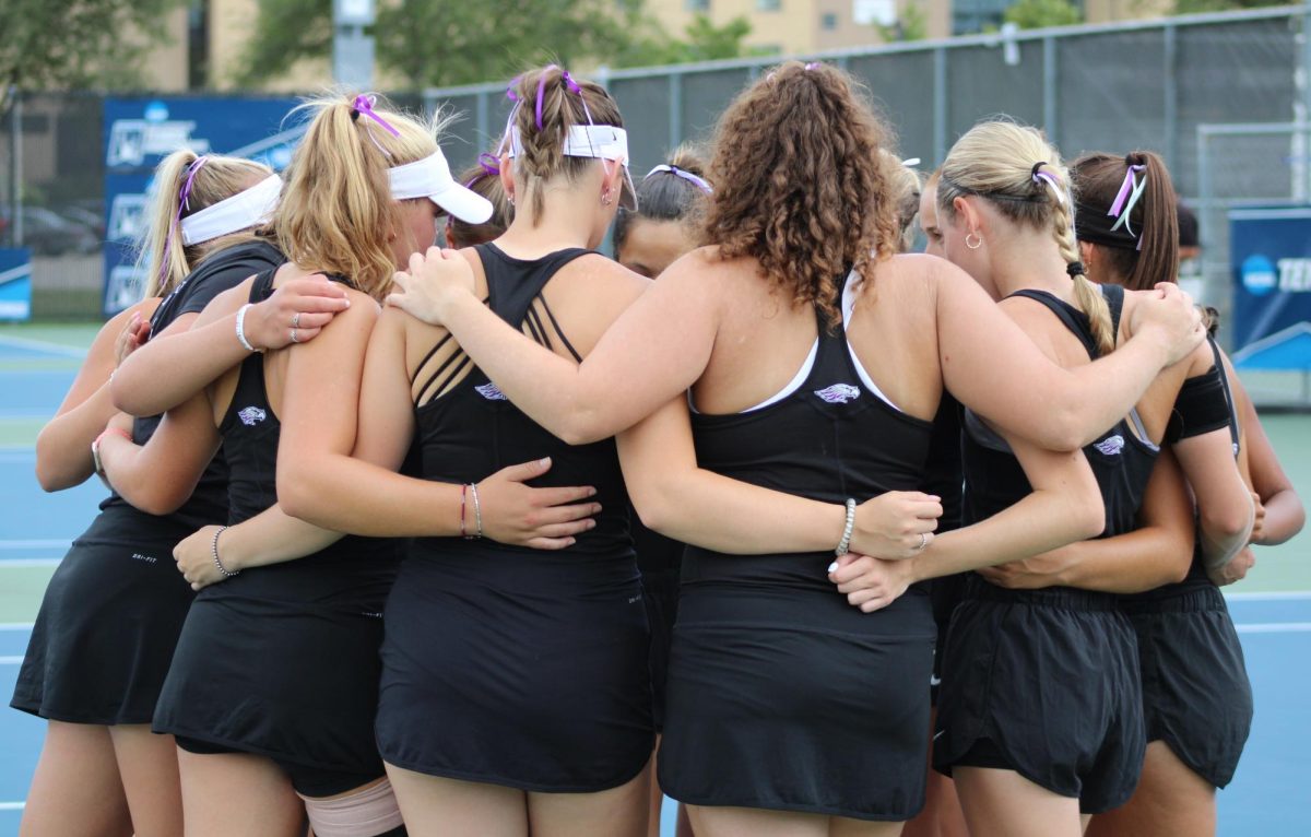 The Warhawks take a moment to circle up and carry on their tradition of putting their right foot into the middle of the huddle as they prepare for their first match of the 2024-25 season against UW-La Crosse at the Warhawk Outdoor Tennis Complex, Friday, August 30, 2024.