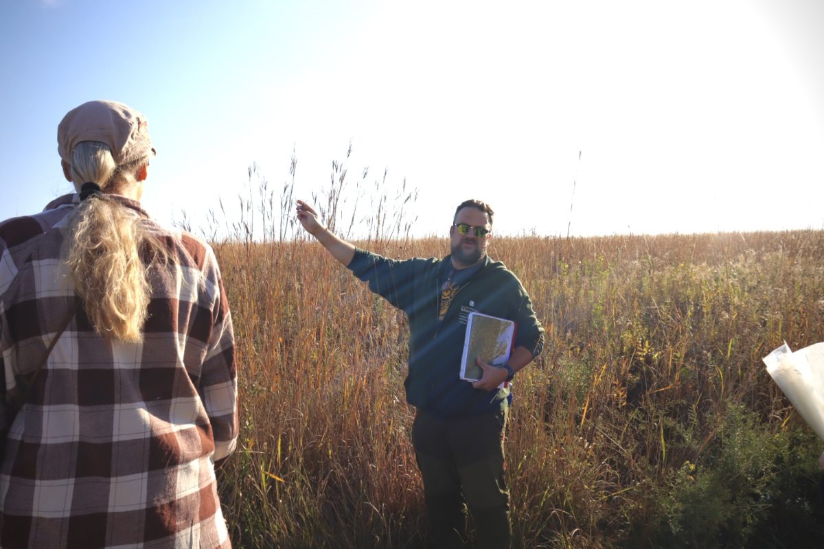 UW-Sustainability Coordinator Wesley Enterline shows volunteers types of grasses they will be harvesting for the event, Sunday, October 12, 2024.