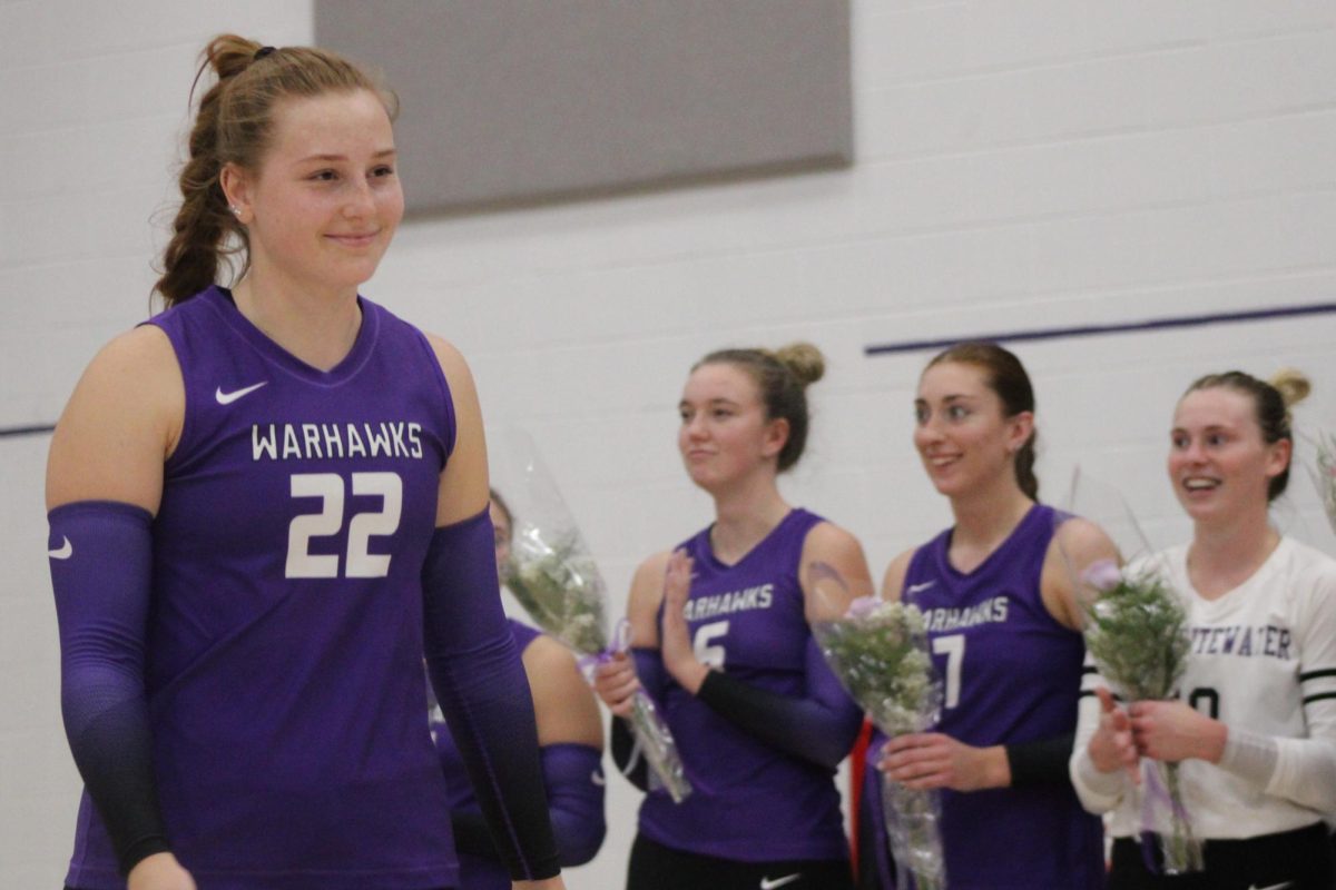 Senior right side Payton Kuepers (22) rejoices over senior night alongside her and her peers. The 7th-ranked UW-Whitewater Warhawks took down the 17th-ranked UW-Platteville Pioneers, sweeping them 3-0 at the Kris Russell Volleyball Arena Wednesday, Oct. 30. 
[Right to left: Kuepers, graduate student middle hitter Hannah Proctor (6), graduate student middle hitter Ava Rebarchik (7), graduate student libero Jaedynn Evans (10)].
