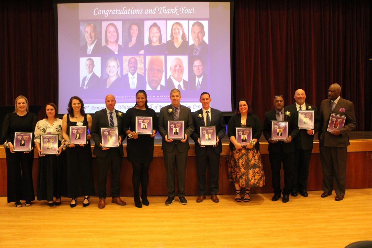 The 2024 UW-Whitewater Hall of Fame class of 2024 poses with their plaques inside the Hamilton Room in the University Center Saturday, Nov. 2. From left: Casie Uttech Schroeder, Amy Gahl-Sweeney, Suzanne Gersich Huss, Pat Miller, Tiffany Morton, Jace Rindahl, Jeff Schebler, Beth Proeber, Ricky Spicer, Bob Wickman, Bob Stone. 
