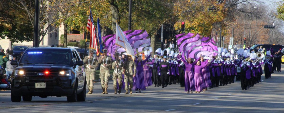 A Whitewater police car, ROTC flag bearers, Color guard, and the Warhawk Marching Band lead the beginning of the parade on main street, Saturday morning, November 2, 2024.