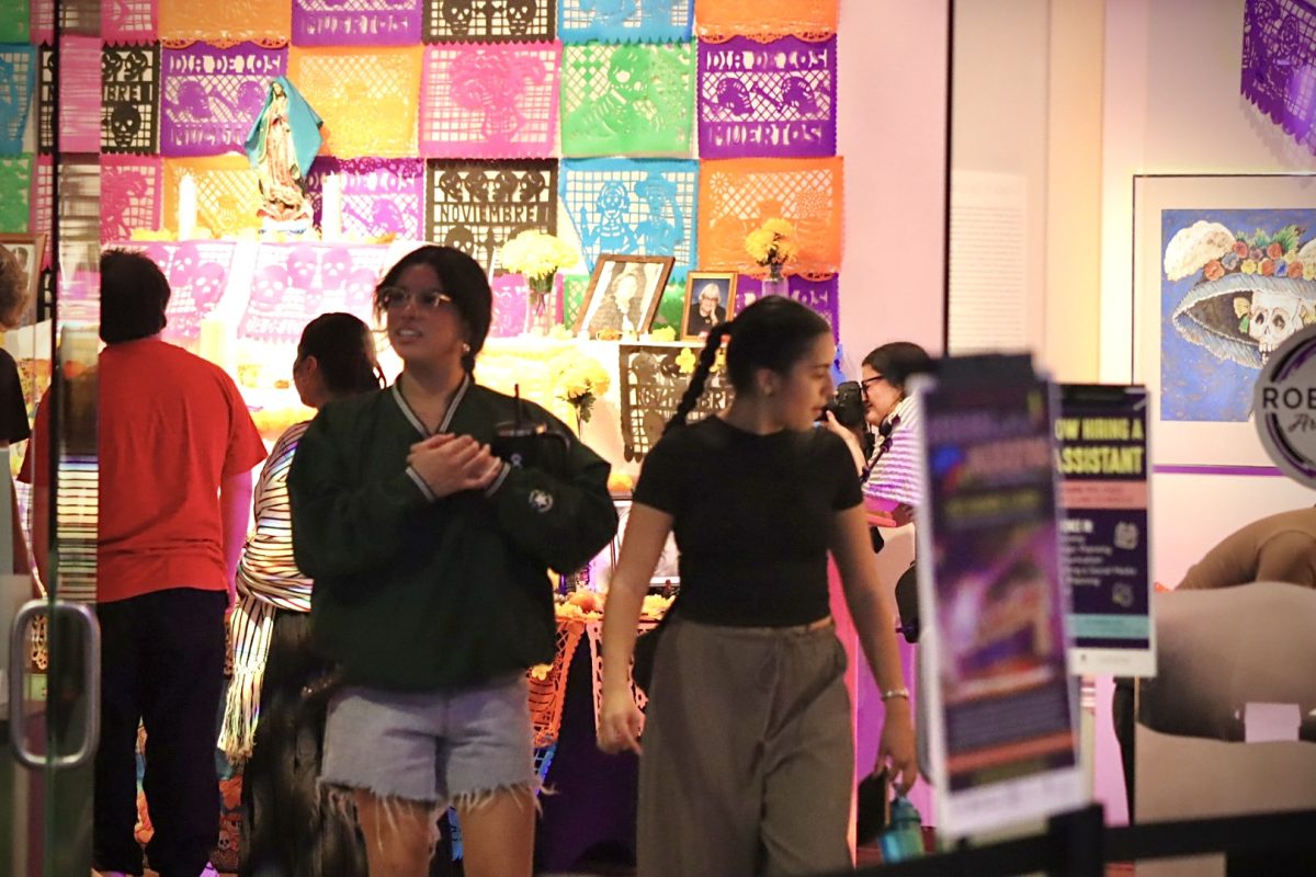 Students gather for the Roberta’s Art Gallery immersive exhibit of Dia de Los Muertos and visit the ofrenda that is set up in the gallery that is situated in the James R. Connor University Center, Tuesday night, October 29, 2024.