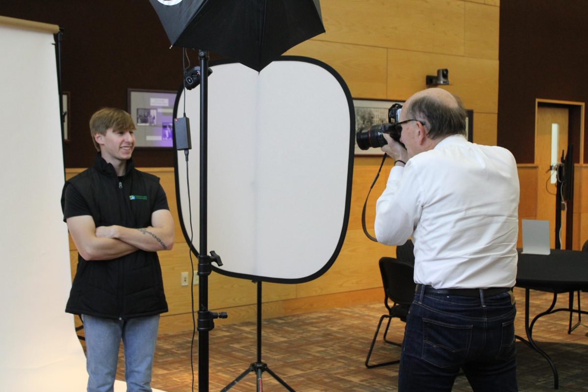 Campus photographer Chris Schreiner takes the photo of Graduate Jaden Nickelsen, hired for a Land Management position, Nov. 3 2024.