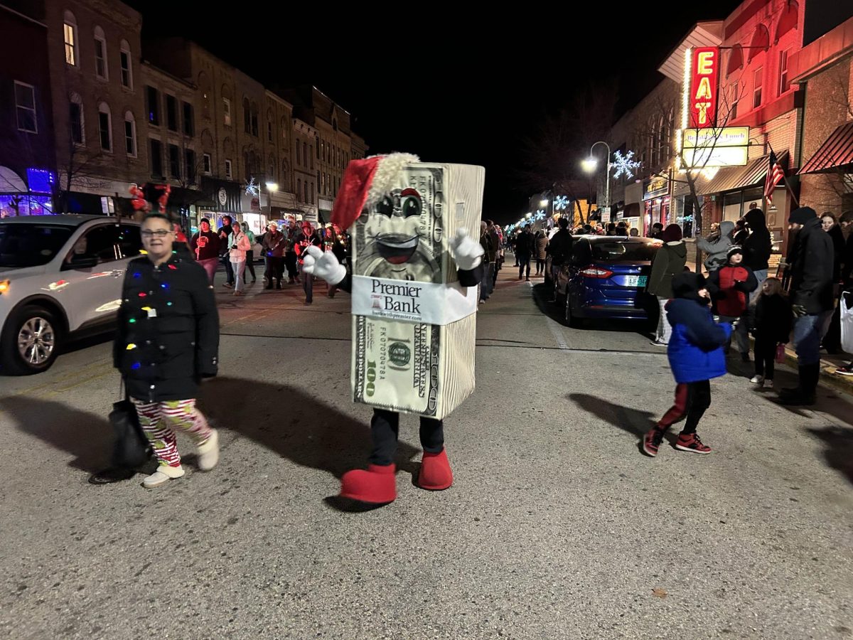 The Premier Bank mascot marches merrily down Main, December 6, 2024.