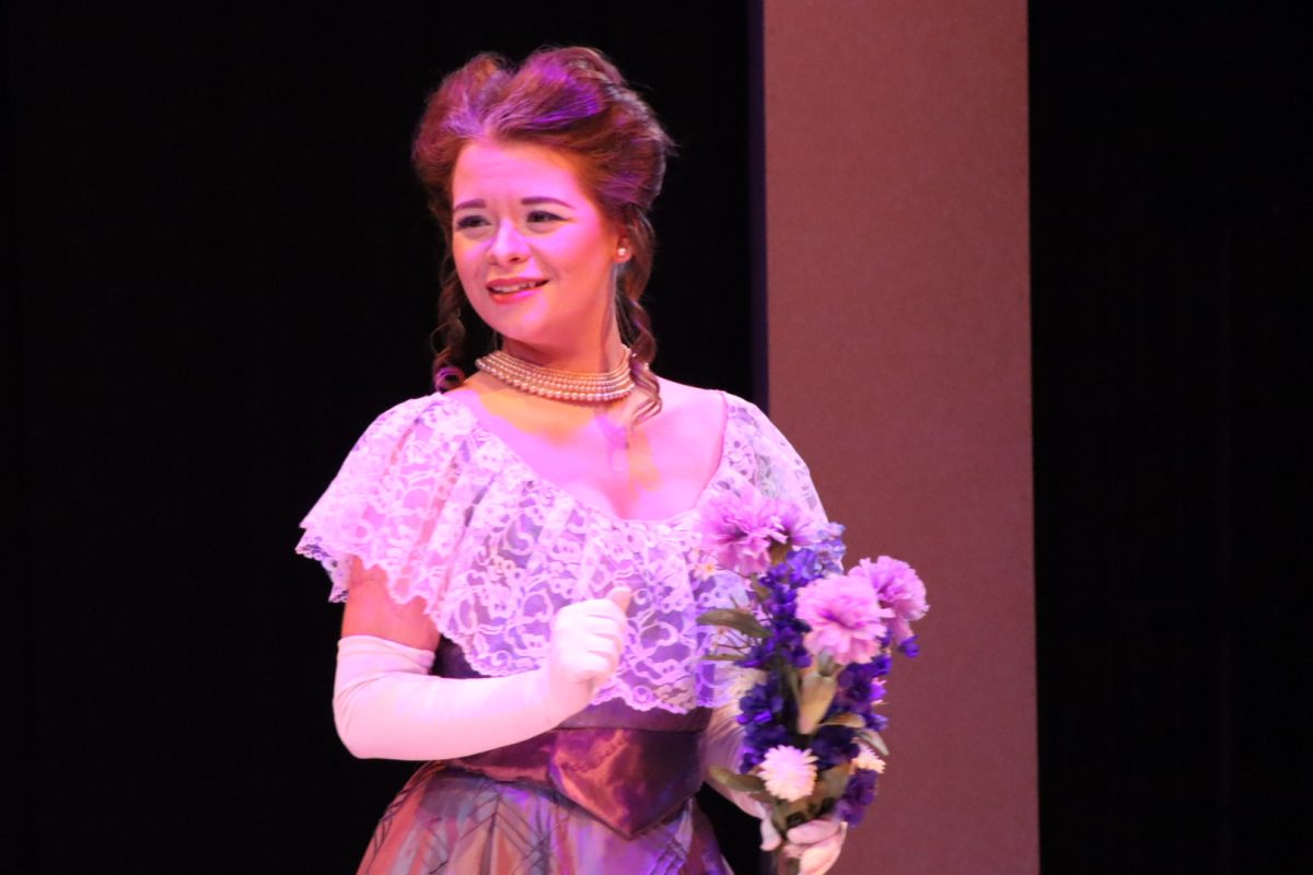 Anna Olson who plays Mrs. Erlynne glances over at Lord Windermere  with her flowers during the dress rehearsal for Lady Windermere's Fan, October 3, 2024.