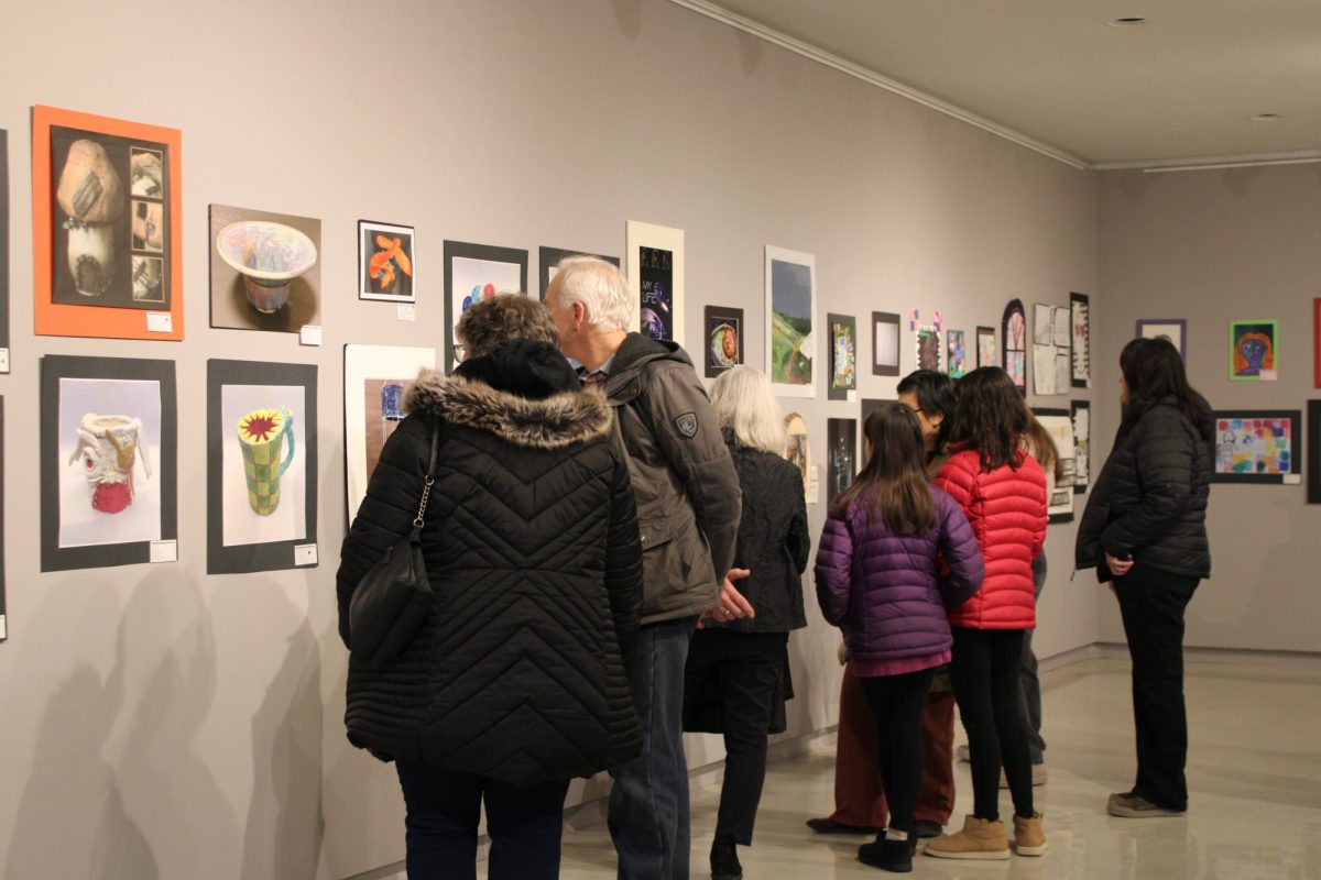 A group of friends and family of the young artists surveying the art pieces for the Regional Youth Art Month Show on Feb. 8. 2025.