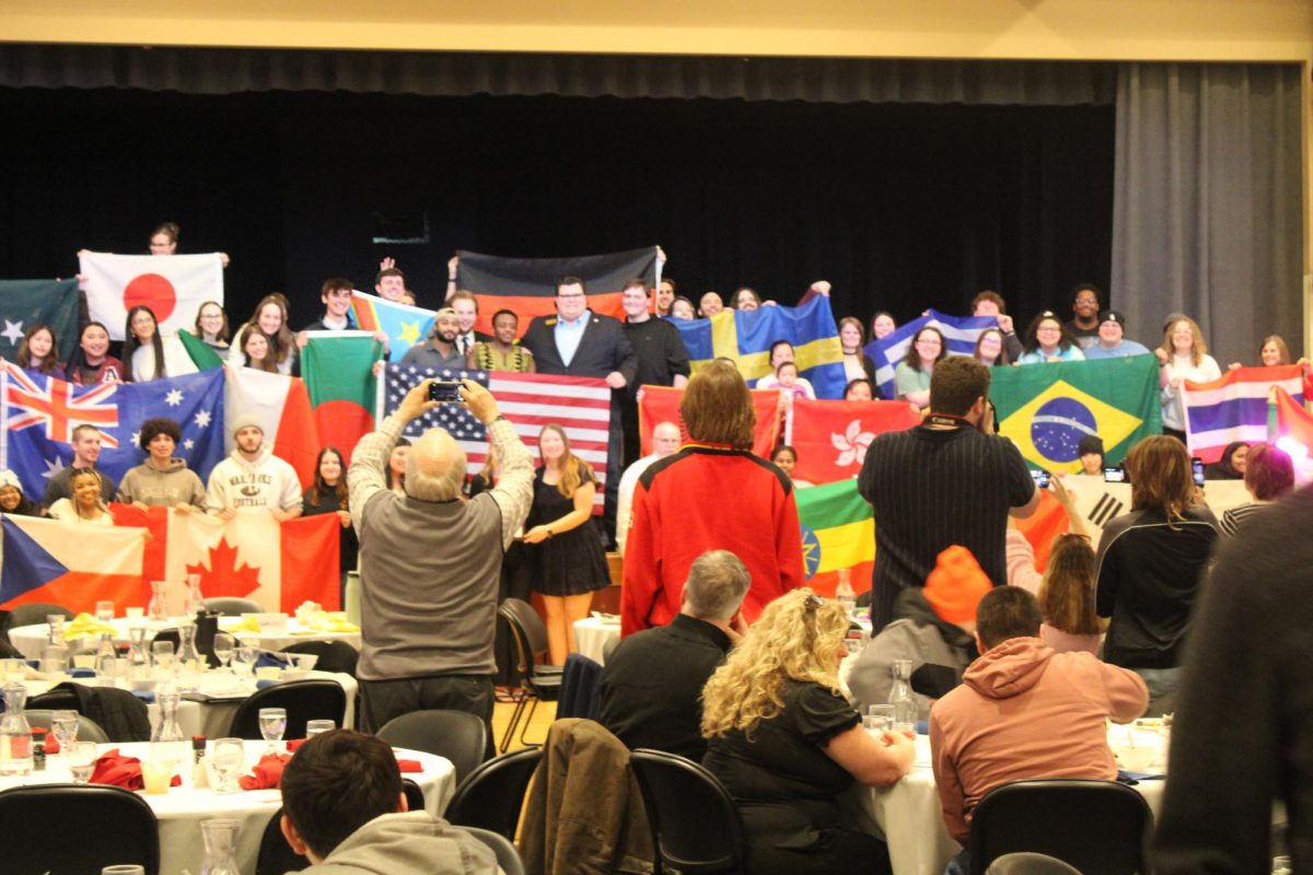 International dinner guests pose with the flags from their corresponding table, Friday, Mar. 8th, 2025.