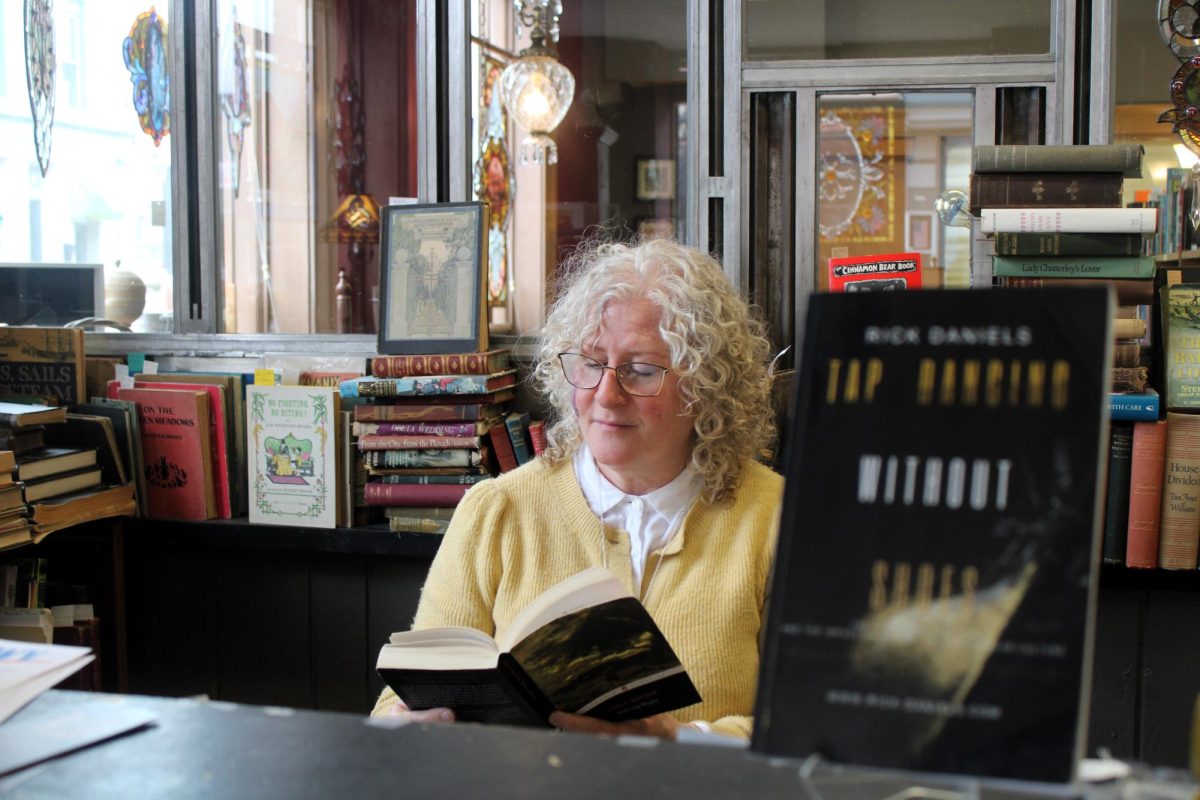 Karen McCulloch reading a book at the front desk of The Book Teller on February 26, 2025.
