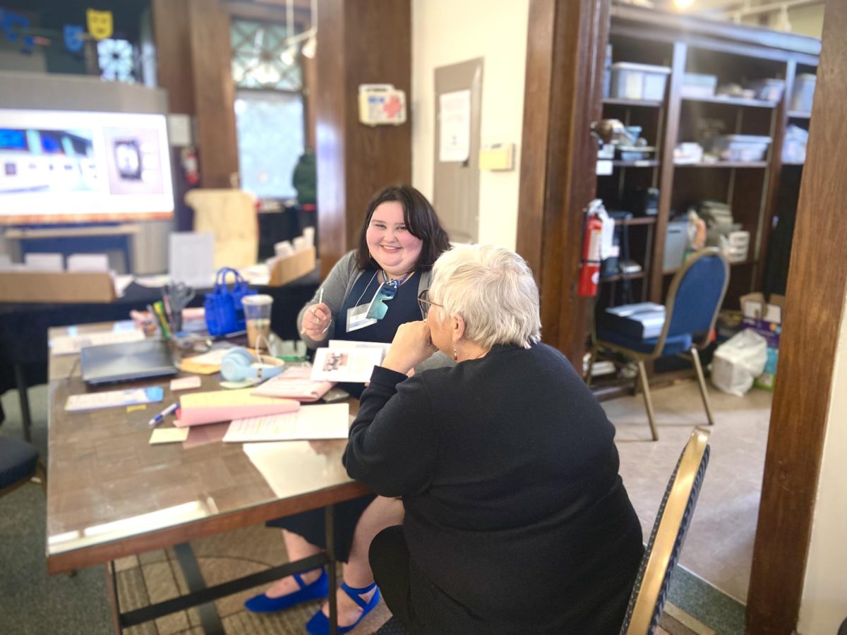 Caryana Dominguez (left) a Whitewater Arts Alliance employee smiles with (right) Jodie Raddatz a volunteer for the arts sale and exhibition artist Thomas Lance, Thursday afternoon, March 21, 2024.