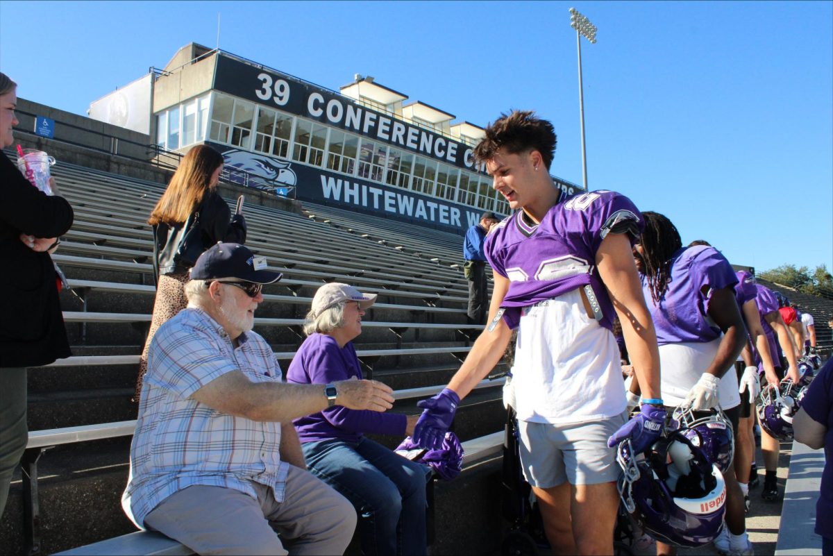 Football players lined up after practice to shake the hands of Fairhaven residents
