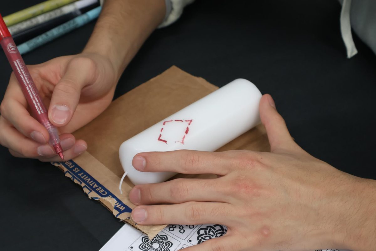Senior Marco Cortes-Lema adds a diamond to his candle during the Warhawk Connection Center’s Diwali candle decorating workshop.