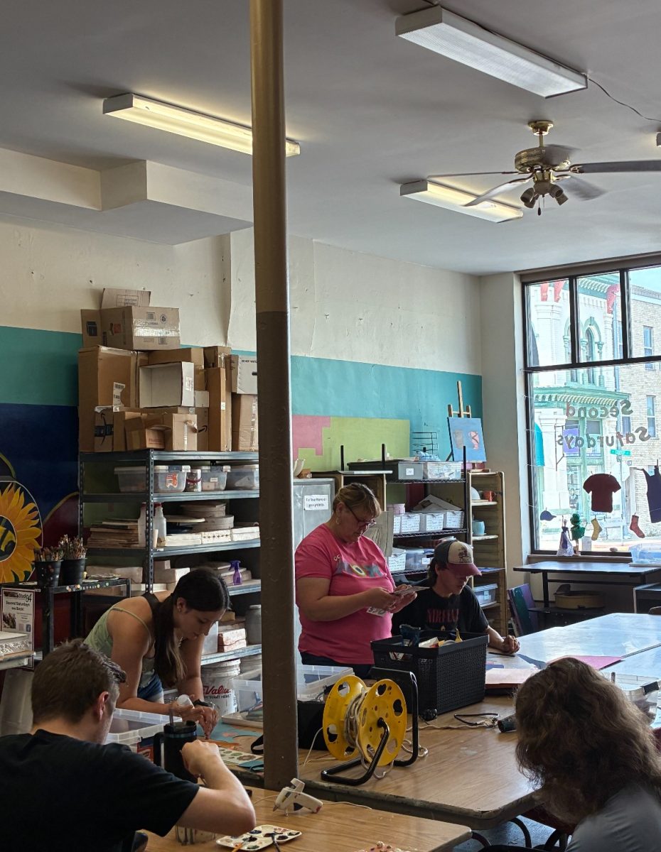 Community members glue and paint their artwork during the Second Saturday event.
