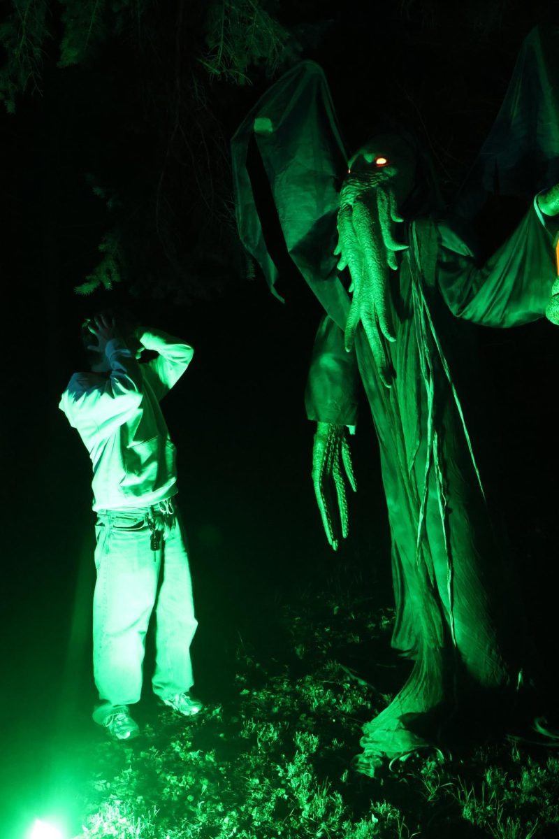 Freshman Aaron Marcus pretends to be afraid of the decorative monster at Nightmare on Woodfield Lane.
