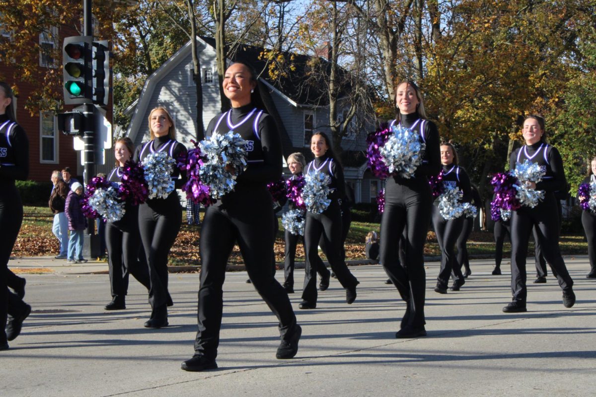 Members of UW-W’s cheer team march in the Homecoming Parade performing Warhawk Strut, Nov. 2, 2024.