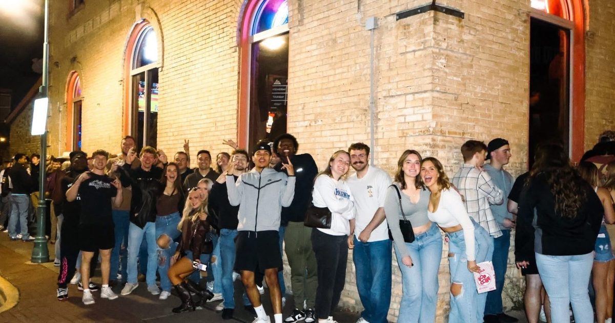 A group of college students line up outside of Pumpers and Mitchell’s.
