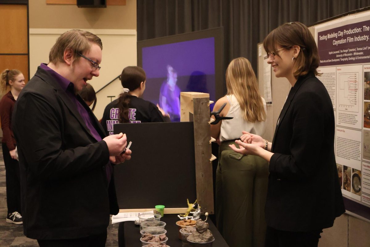 Junior Lescamela shares the oil-based clay samples with associate director of Undergraduate Research Innovation and Creative Activities Program Brain Schanen. 