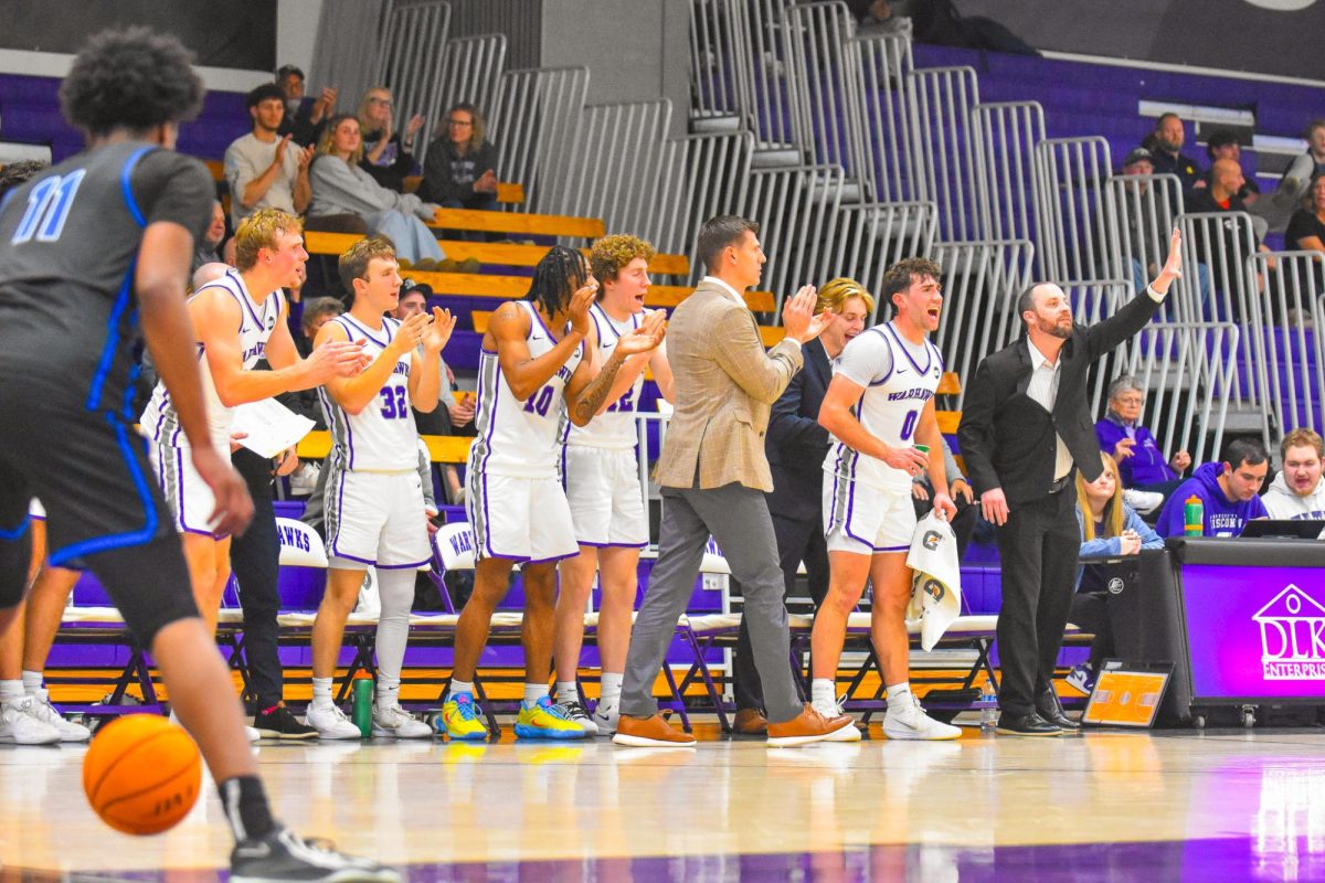 The UW-Whitewater men’s basketball team benches cheers as the Warhawks advance their lead against Aurora University on Nov. 19, 2025 at the Kachel Gymnasium.