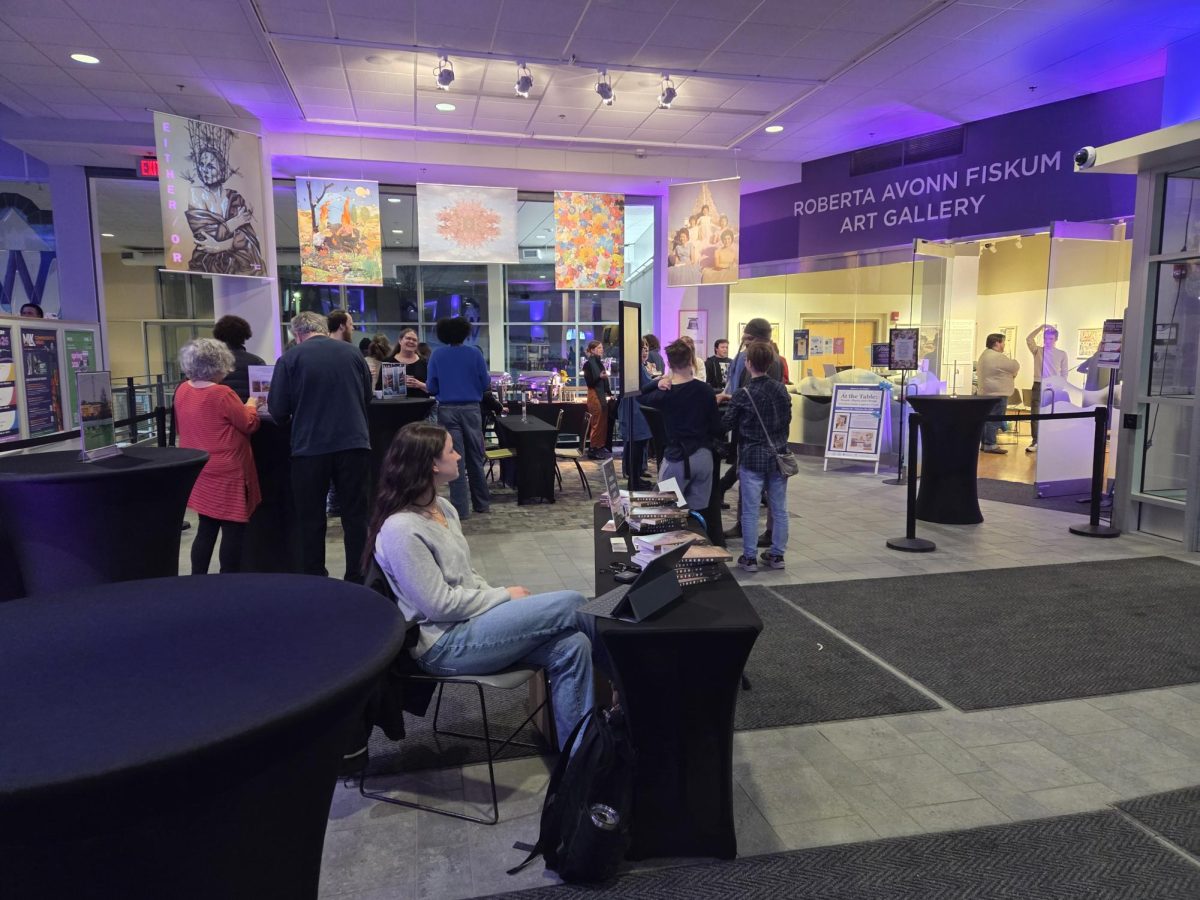 The crowd for the release party grew as the start time approached, people helping themselves to food on the table or mingling in front of Roberta’s Art Gallery. The table in front shows the option of purchasing Either/Or at the event on Feb. 5, 2026.