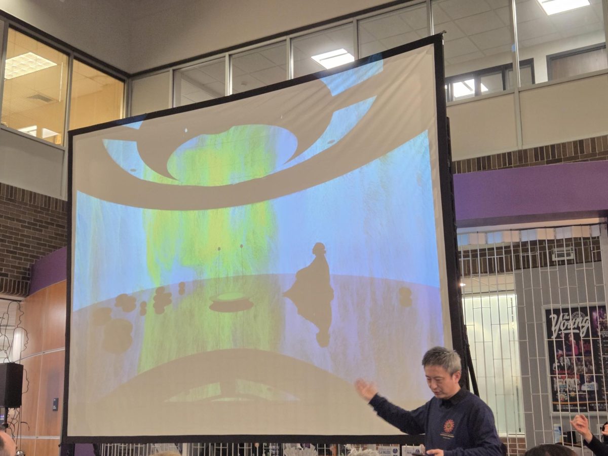  Fei Jun explains one of his pieces in the gallery and how he created it with the use of AI on March 4, 2026 in the Center of the Arts atrium.