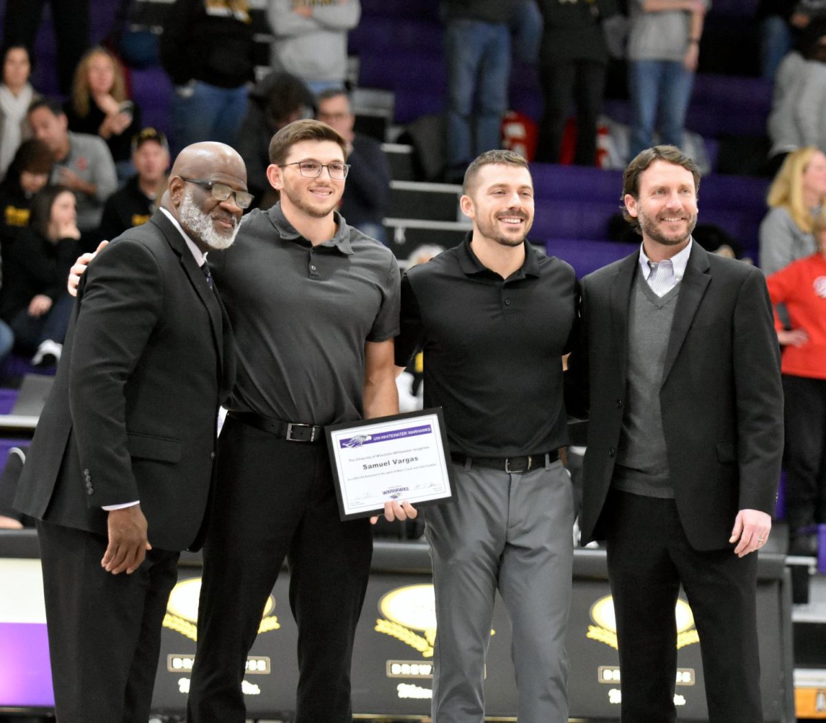  The UW-Whitewater All American Honor Night features Chancellor Corey A. King, Men’s Track freshman Warhawk Sam Vargas, Short Sprints Associate Head Coach Josh Ireland, and Director of Intercollegiate Athletics Ryan Callahan smile as Vargas is honored in the Kachel Gymnasium, Feb. 28, 2026. 
